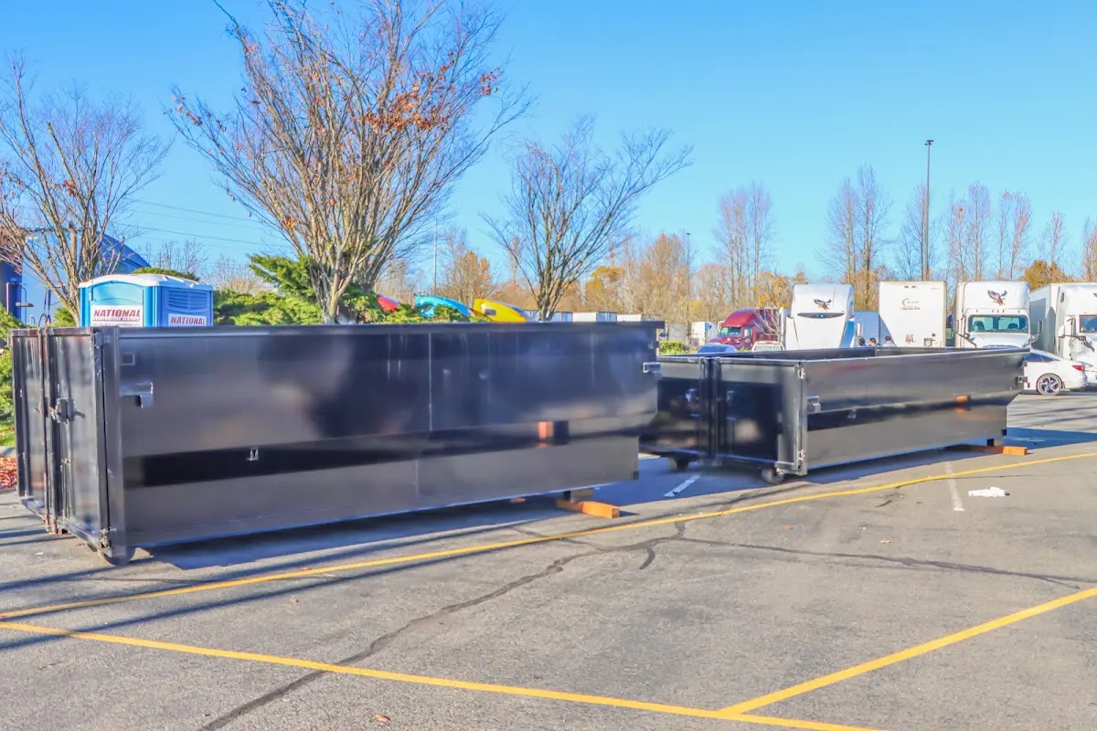 Professional dumpster rental service with roll-off container on residential driveway in Victorville